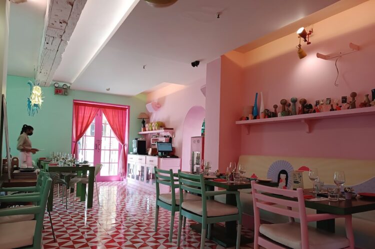 Playful pastel cafe interior in mint green and pink with decorative props and patterned flooring designed by Nail and Hammer