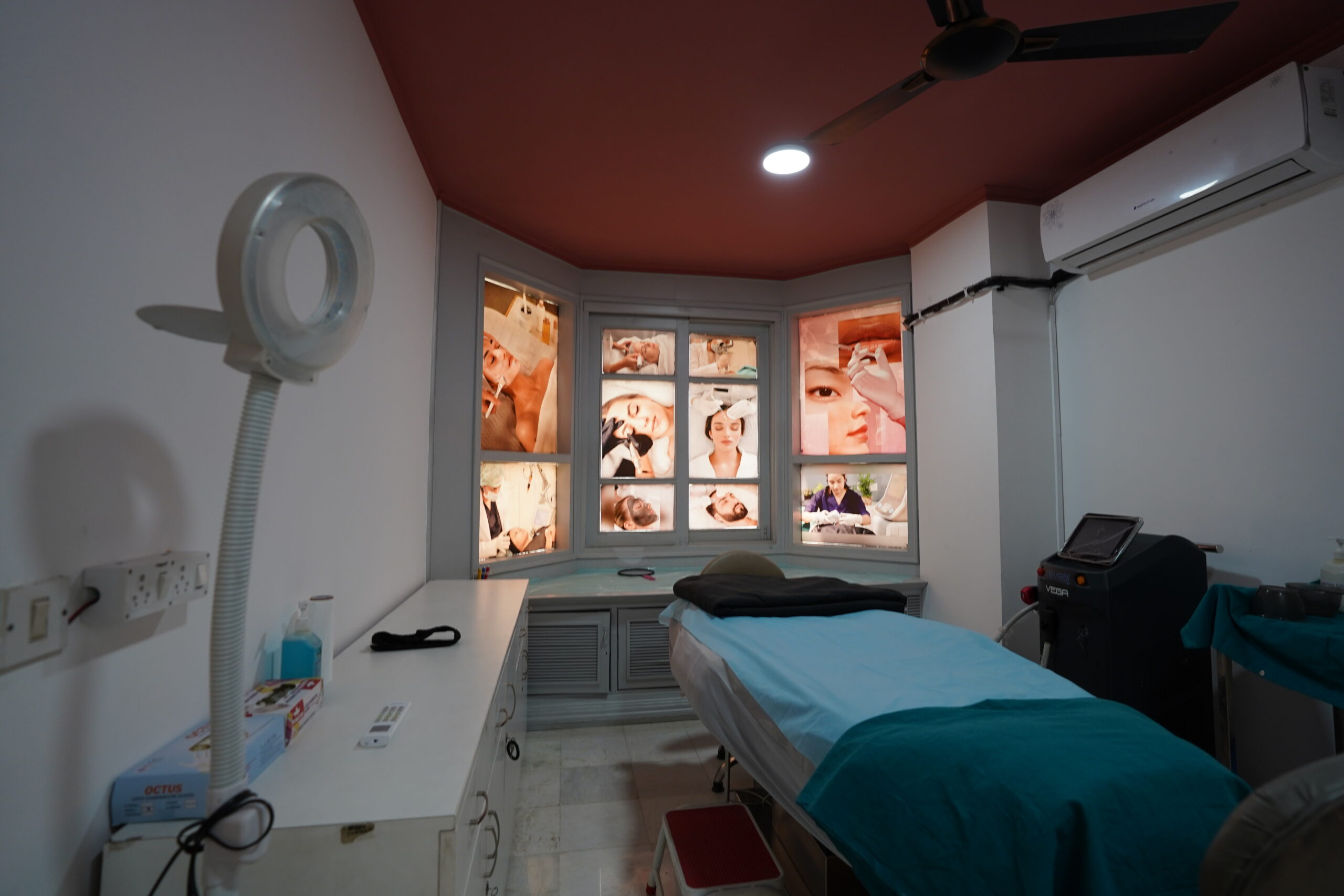 Dr. Jyoti Clinic dermatology treatment room with backlit photo display and treatment bed