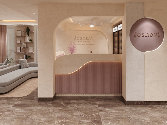 Joshavi clinic entrance with arched reception, fluted blush pink counter and round Joshavi logo wall panel